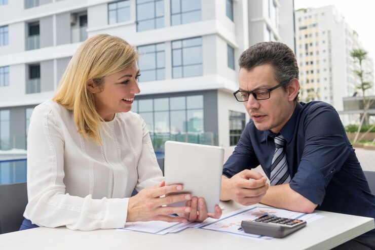 Mujer y hombre de negocios conversando sobre préstamos para pymes